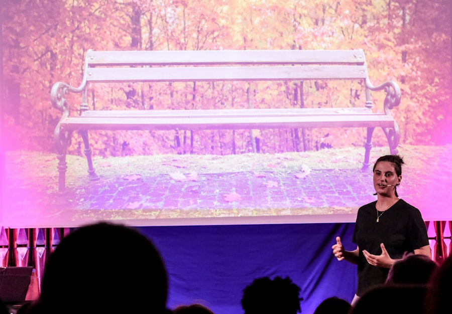 Woman presenting on stage in front of a seated audience