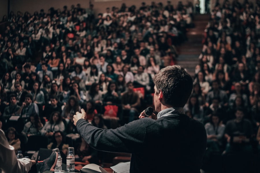 Host addressing a large auditorium crowd with a microphone