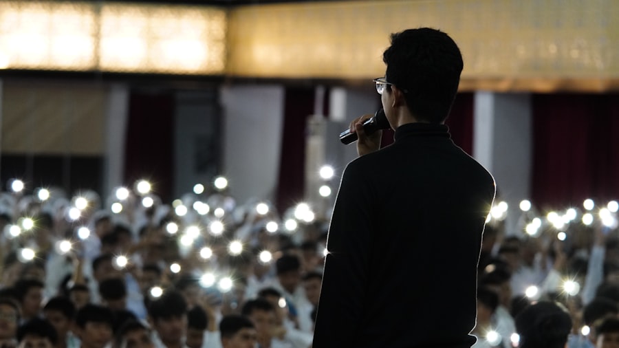 Silhouette of a host on stage with the crowd's phone lights raised