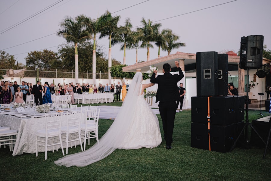 Bride and groom walking into their reception as guests cheer