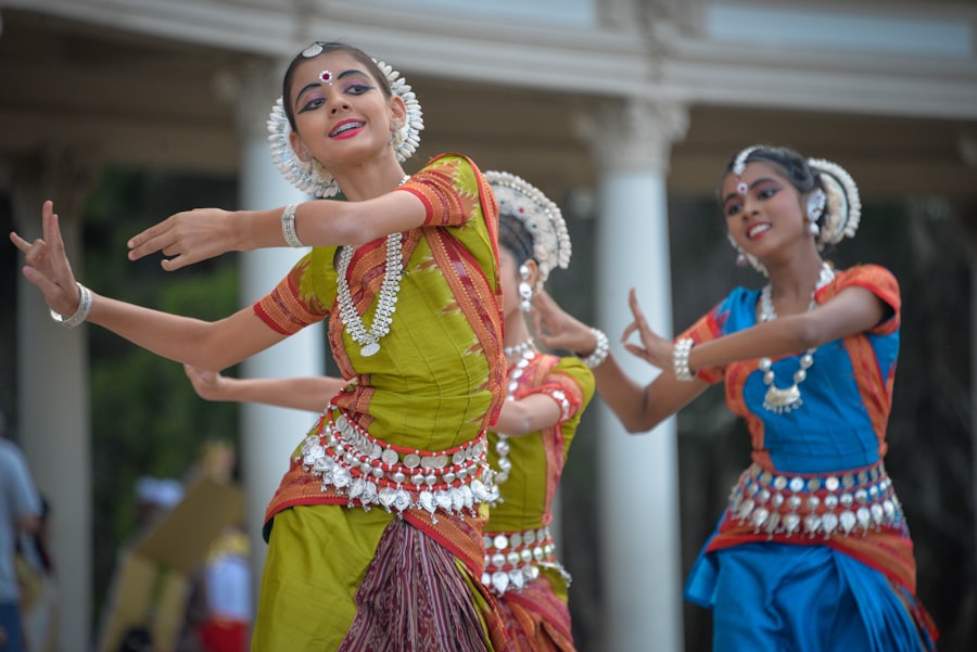 Three dancers in traditional Odissi costume performing