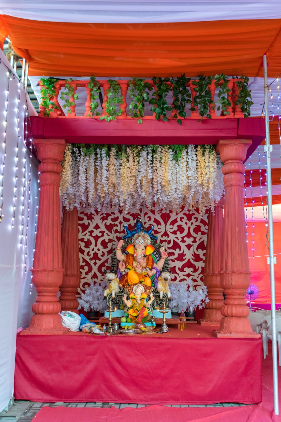 Ganesh idol installation with floral drapes and greenery