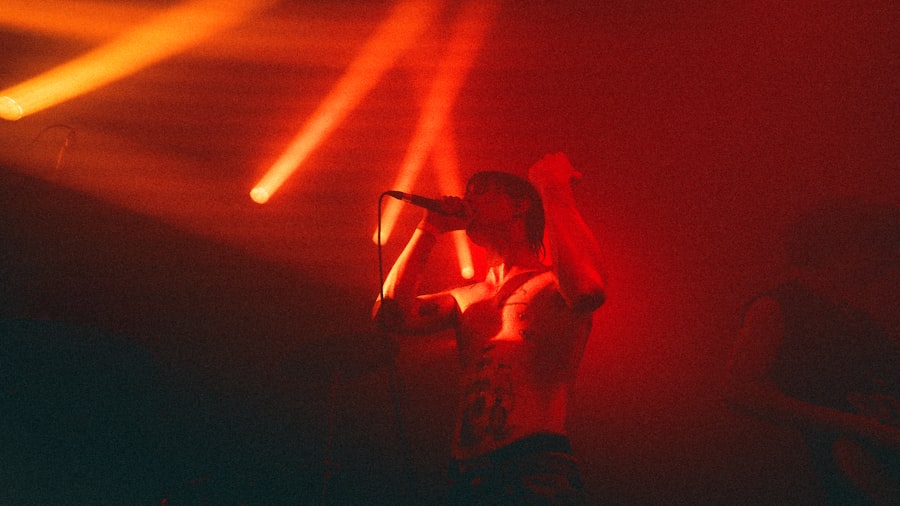 Performer singing under dramatic red stage lighting