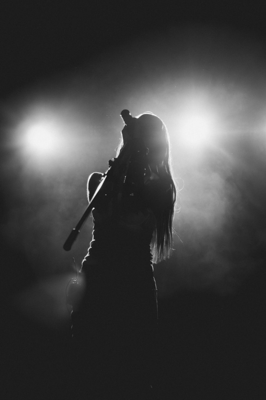Silhouette of a singer performing under bright stage lights