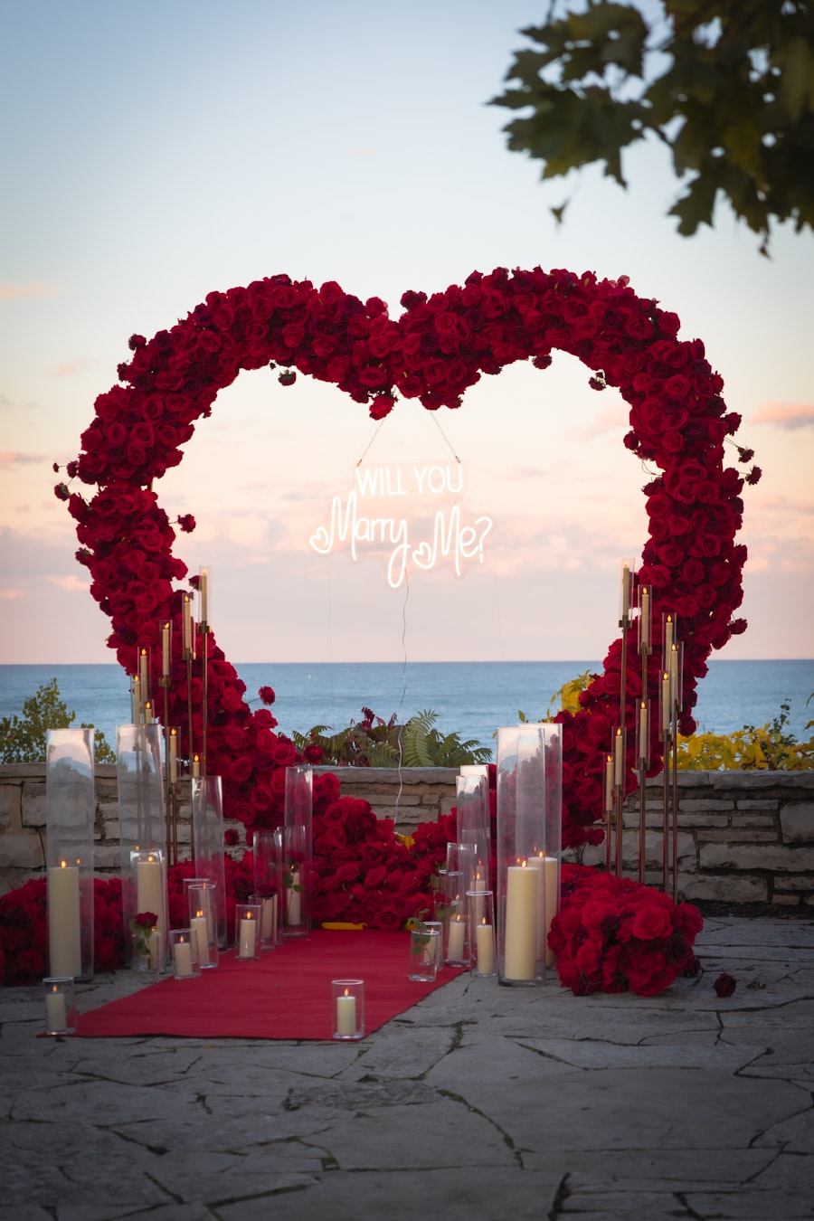 Heart-shaped rose arch entry with candles by the sea