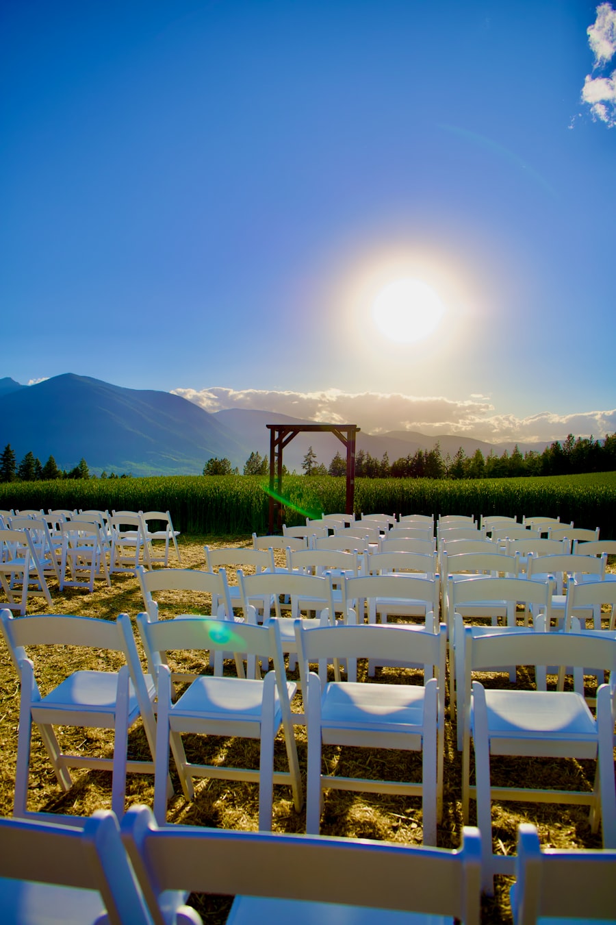Wooden entry arch framed against mountains at an outdoor ceremony