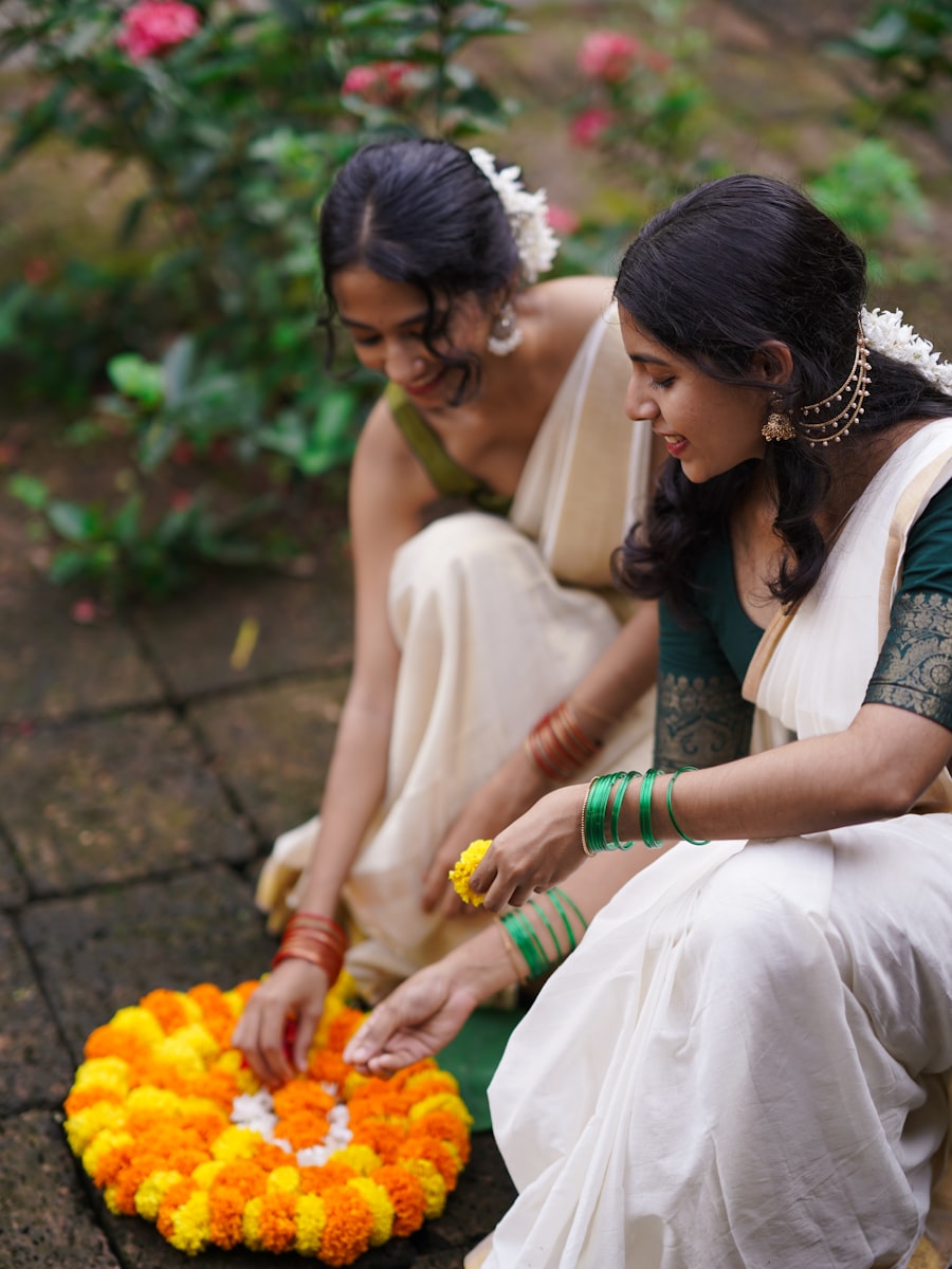 Hands arranging a marigold flower rangoli
