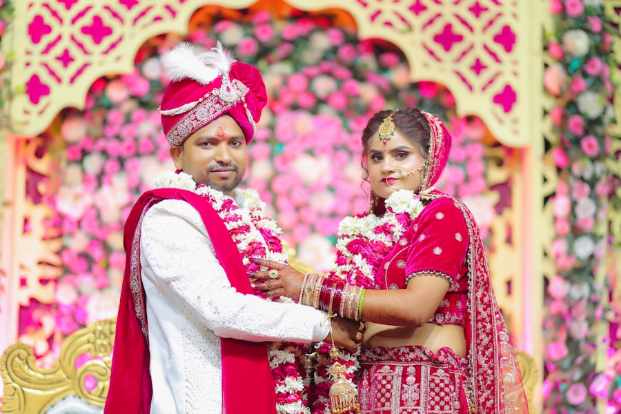 Couple standing before a pink floral wedding backdrop