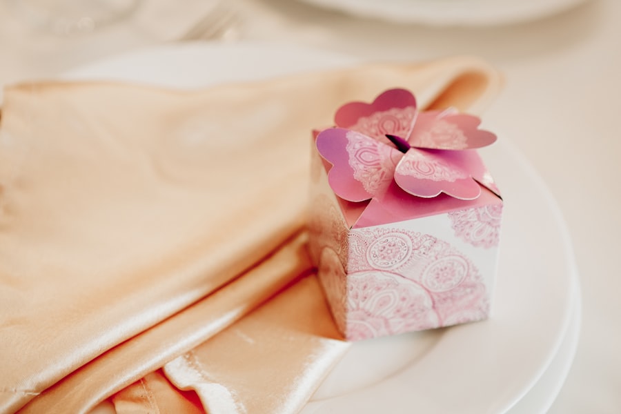 Pink paisley-patterned wedding favor box on a satin napkin