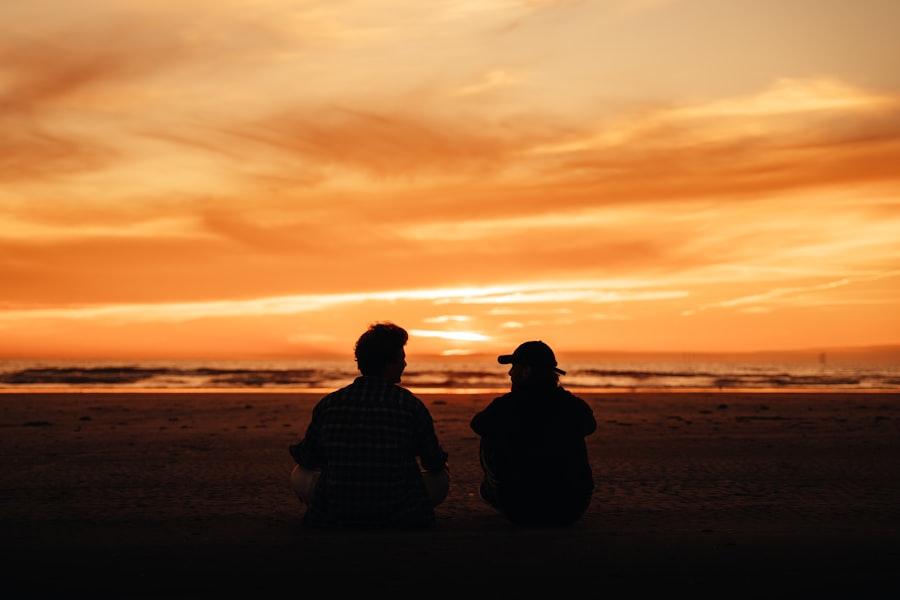 Couple sitting together on the beach watching the sunset