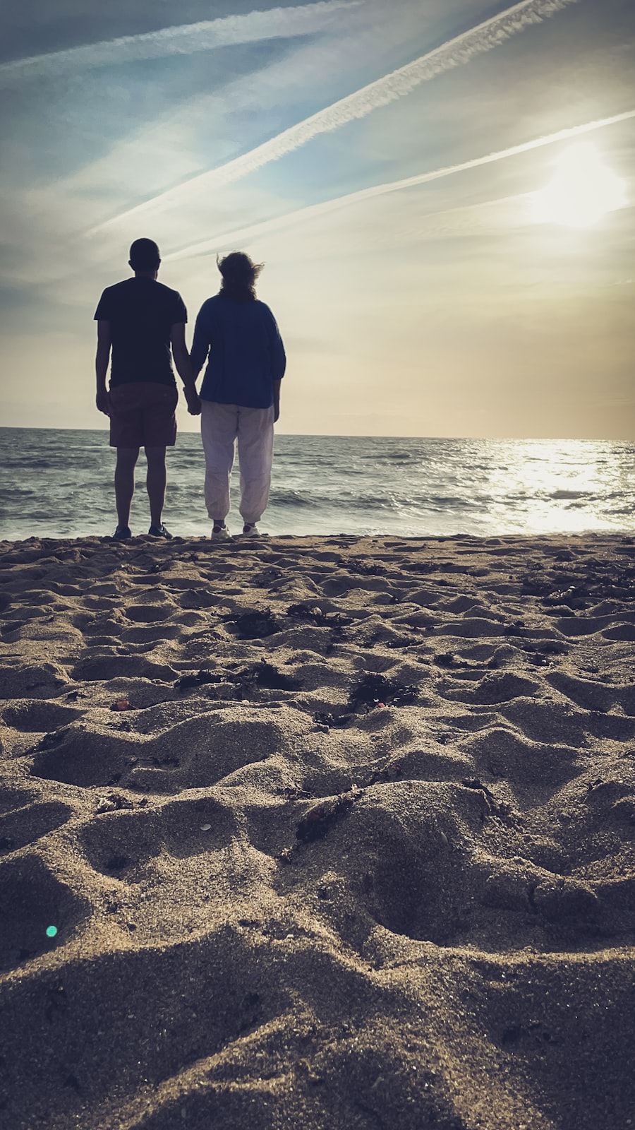 Couple holding hands on the beach at sunset