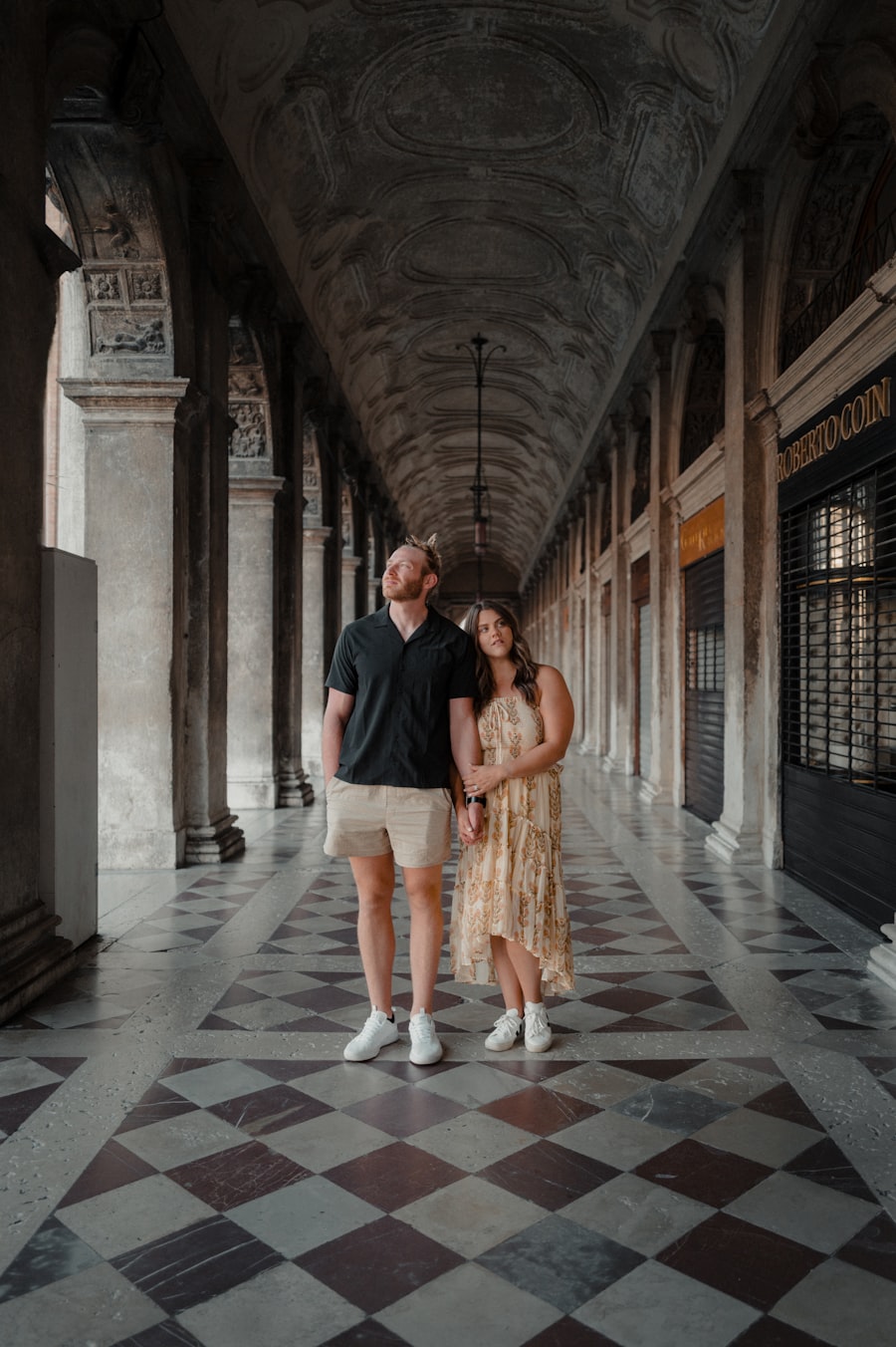Couple walking through a grand marble arcade in Venice