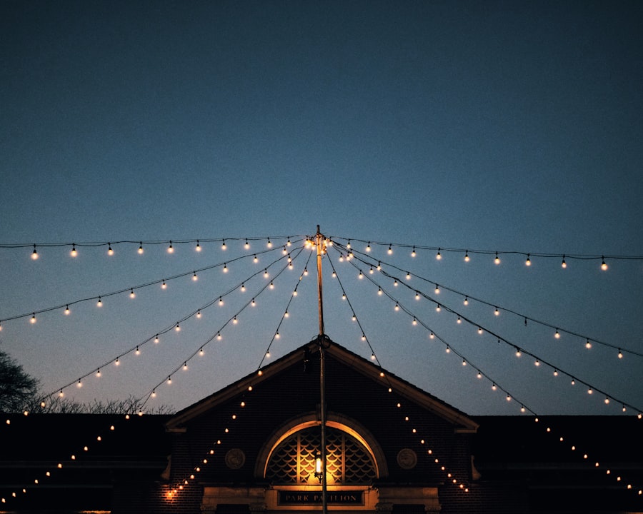 String lights radiating from a pole over a pavilion at dusk