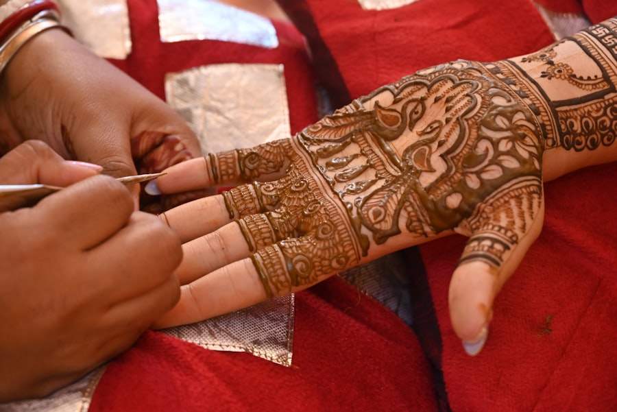 Mehendi artist finishing an intricate peacock henna design