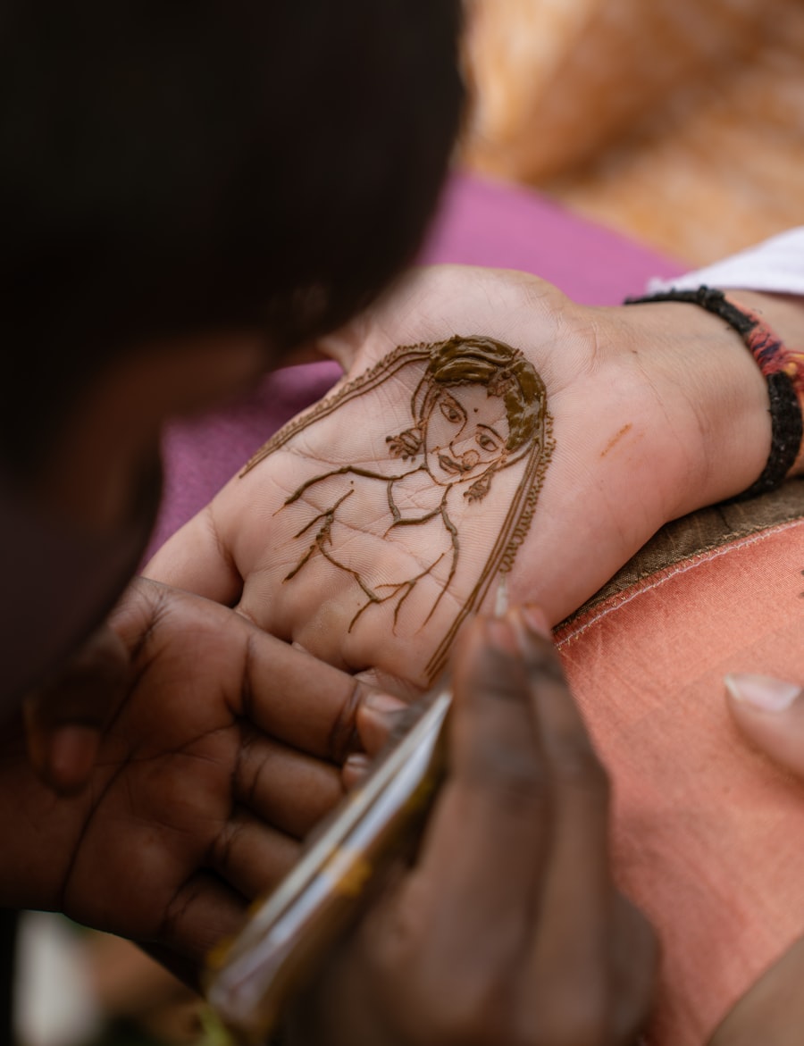 Mehendi artist sketching a bridal portrait design in henna