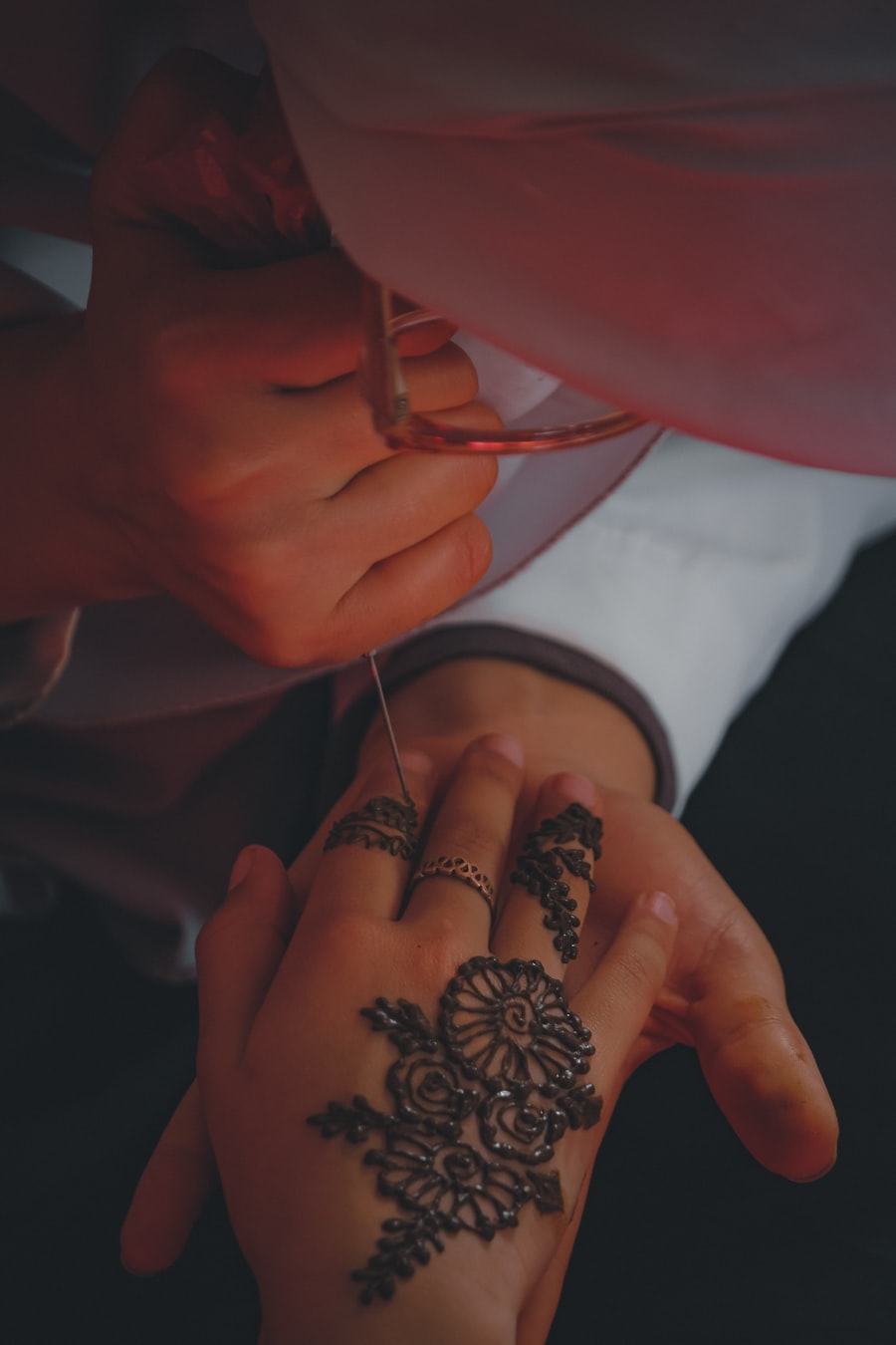 Mehendi artist tracing a rose design in henna