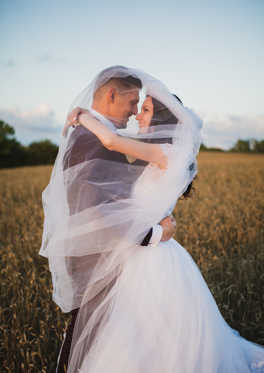 Couple embracing under a veil in a golden wheat field