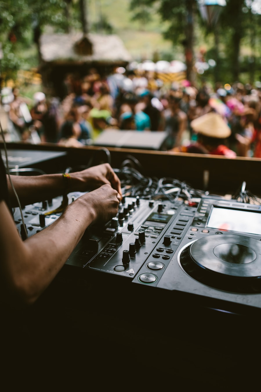 DJ mixing outdoors in front of a festival crowd