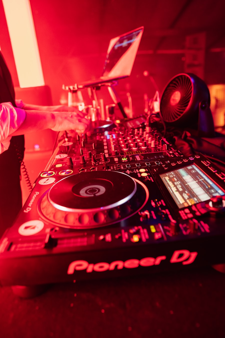 DJ booth set up under string lights at a wedding marquee