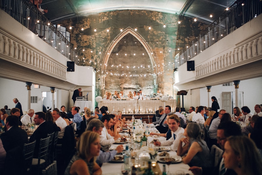 Guests dining under string lights beneath a gothic archway